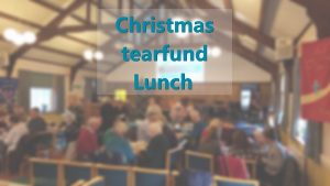 Blurred image of previous Christmas Tearfund Lunch with text Christmas tearfund lunch superimposed